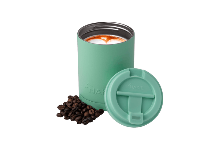 Mint green insulated coffee cup with matching lid, filled with latte, surrounded by coffee beans