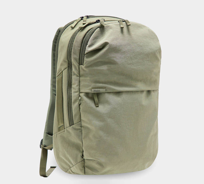 Olive-green canvas daypack backpack with two zip compartments, front zip pocket and padded shoulder straps