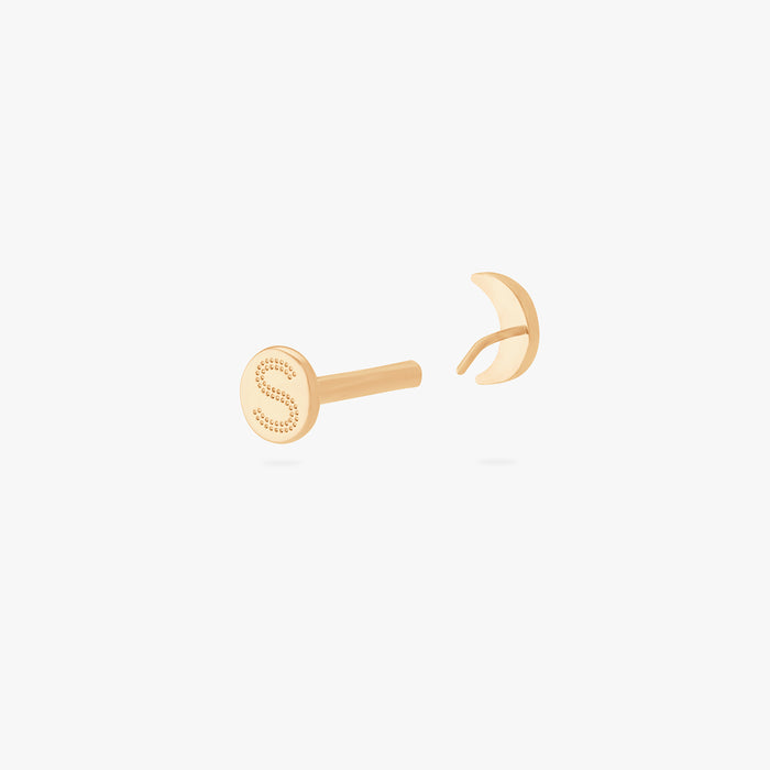 This is an image of a gold moon shaped flatback top with a gold labret with a circle disc with the "S" logo engraved in it. color:null|gold/clear|gold