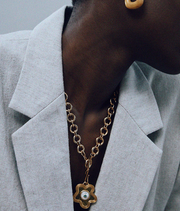 Close-up of model in grey blazer with Mood Necklace in Gold and Porto Pendant in Poppy Pearl.