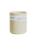 Nette Sunday Chess Candle. Cream-colored candle vessel with minimal white label.