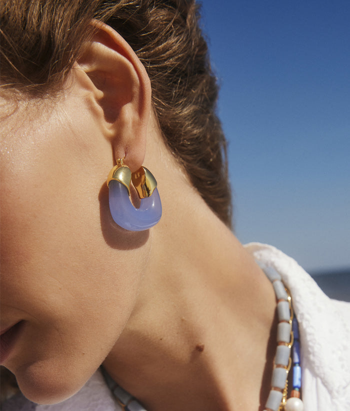 Model in Organic Hoops in Periwinkle in a white top and sky background.