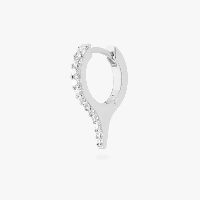 Silver huggie with a spike and small clear stones on a white background