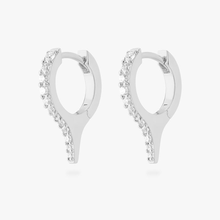 Pair of silver huggies with a spike and small clear stones on a white background