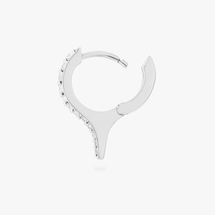 Silver huggie earring with a spike and small clear stones on a white background