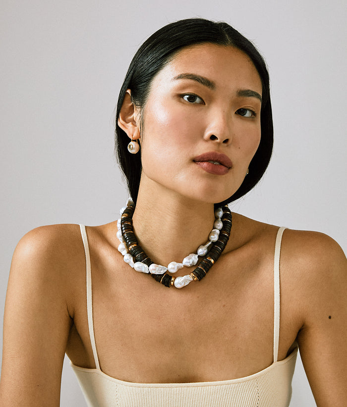 Model on grey backdrop wears cream tank with Bilbao Collar, Claude Necklace and Pearl Pablo Earrings
