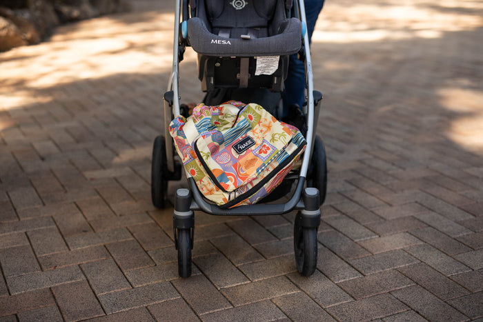 Retro Shores recycled tote bag with colorful sun and wave print displayed in stroller basket, front view