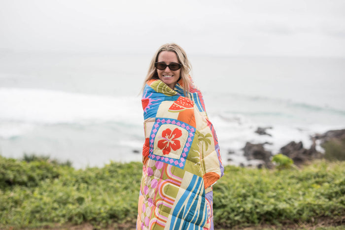 Retro Shores sustainable down puffy blanket with colorful geometric patchwork pattern in orange, blue