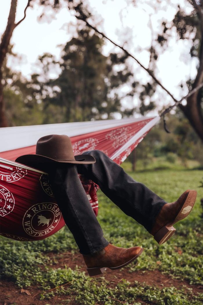 Ringers Western red recycled hammock with white straps, occupied with cowboy hat and brown boots visible
