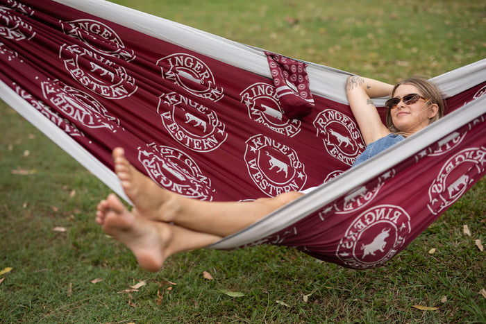 Burgundy Ringers Western hammock with white logo repeat pattern, displayed in use outdoors.