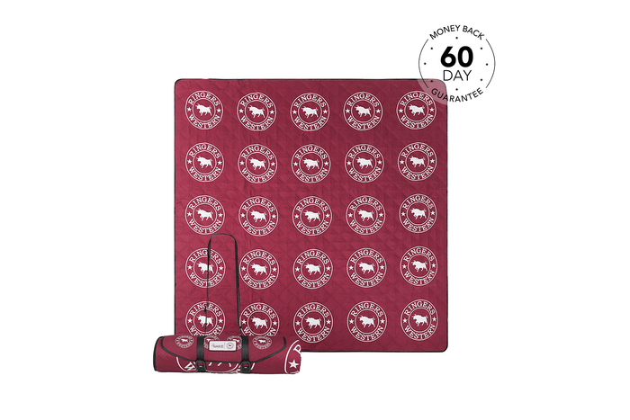Burgundy recycled picnic blanket with Ringers Western logo pattern, rolled with carrying strap shown below