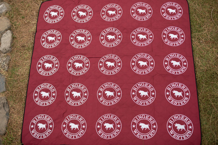 Burgundy picnic blanket with white Ringers Western logo and bull design repeated in grid pattern