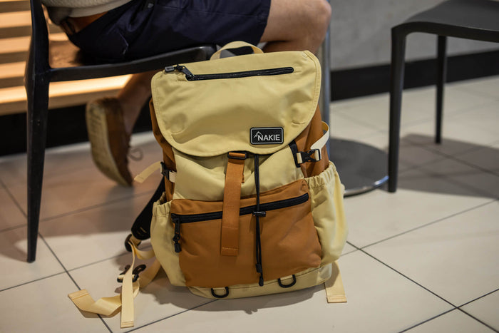 Sahara sand and tan colorblock recycled travel backpack with flap closure, side pockets, and padded straps