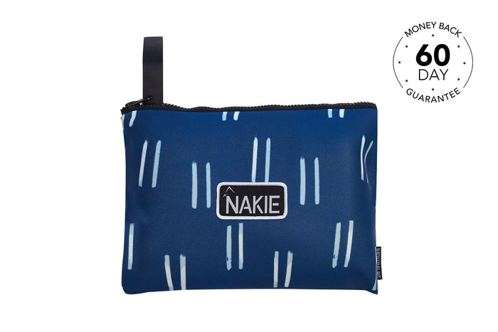 Navy recycled beach towel with white dash pattern and black NAKIE label, featuring carry handle