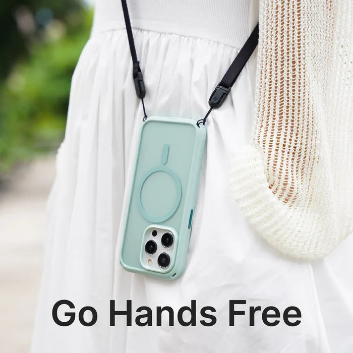 A person in a white knit sweater and skirt carries a smartphone in the Catalyst Case US Shoulder Strap & Ring Stand Bundle, hanging from a black strap around their neck. The text “Go Hands Free” appears over blurred greenery in the background.