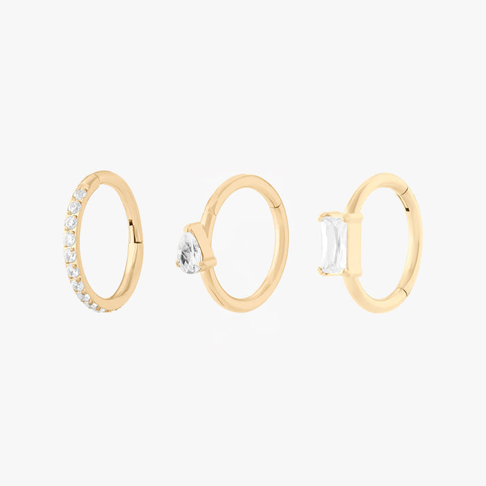 This Sparkle Clicker Set includes a Pave Clicker, Pear CZ Clicker, and Baguette Clicker. These clickers are all gold-toned with clear CZ stone accents, and they are all 8mm in diameter.