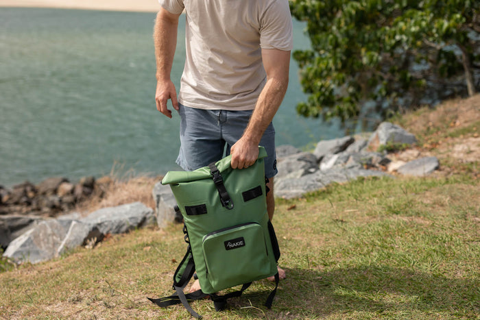 Spring green recycled cooler backpack with black straps, held by man at lakeside