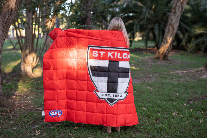 St Kilda Saints red quilted puffy blanket with logo and "EST. 1873" crest, displayed outdoors