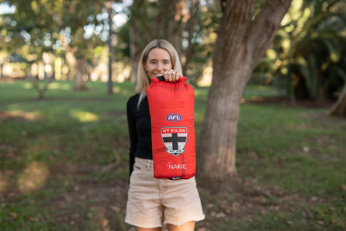 Red St Kilda Saints AFL puffy dry bag with drawstring closure, displayed outdoors