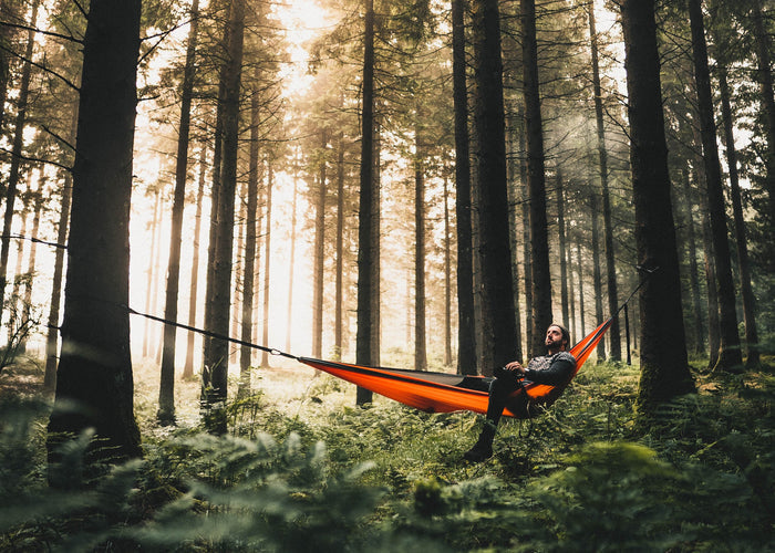 Man in Sunburnt Orange Recycled Double Hammock in forest