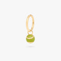 This image shows a green tennis ball charm on a gold clicker