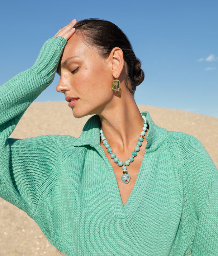 Model at the beach wearing the Tile Earrings in Aqua with Rincon Heart Necklace.