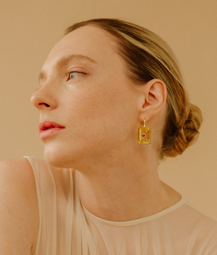 Model in profile wears Tile Earrings in Citrine