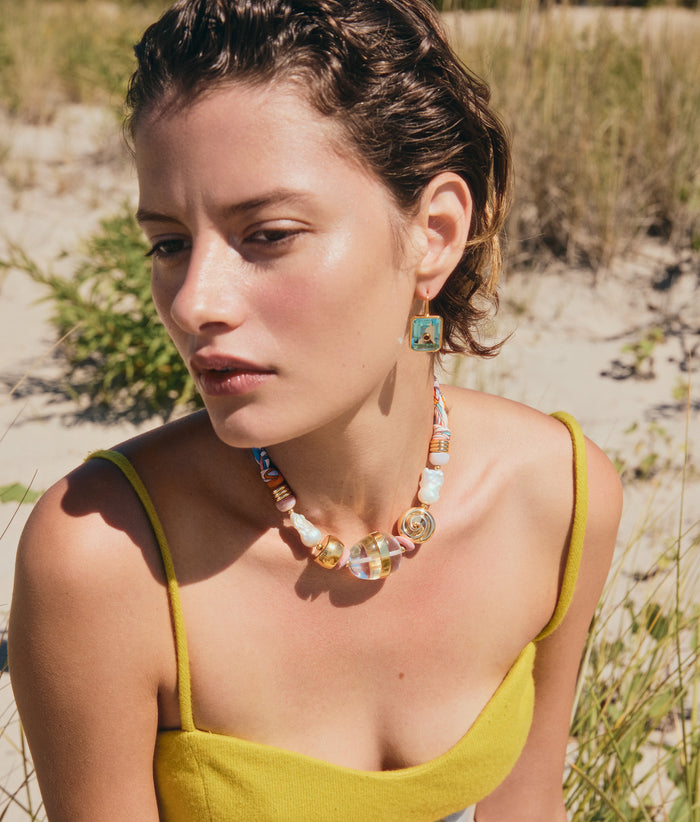 Model on dune grass wears yellow top with Tile Earrings and Glass Beach Necklace