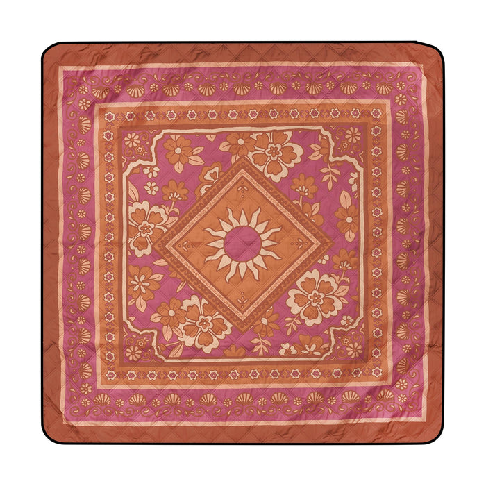 Quilted picnic blanket with burgundy and terracotta floral design, central sun motif, and ornamental borders.