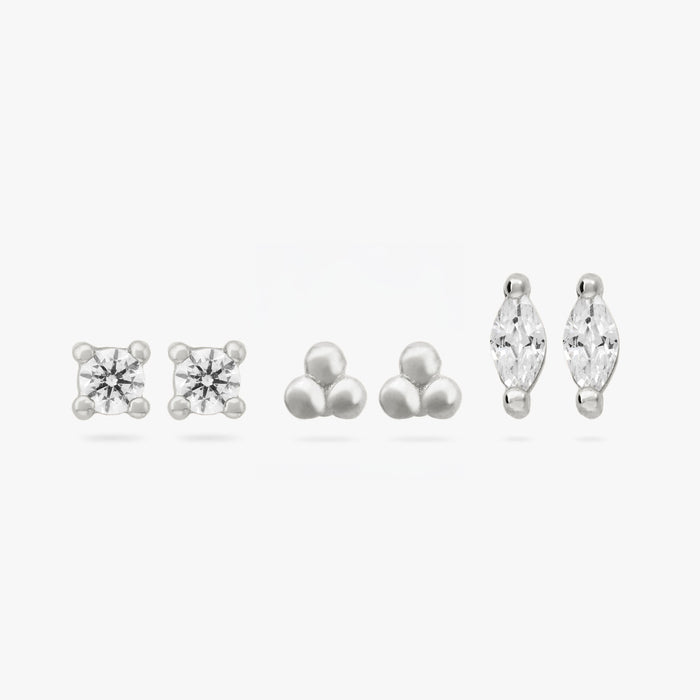 This image shows a set of three pair of  silver plated flatback studs. The set contains a clear cz stone stud, a trinity ball stud and a marquise stud with a clear cz stone.