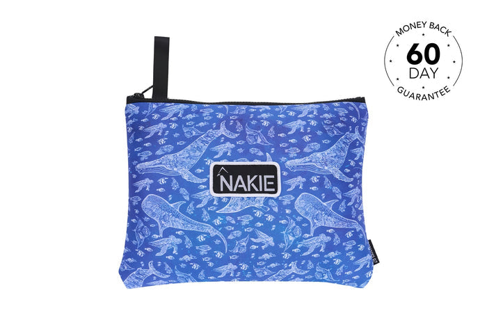 Blue recycled beach towel with white marine life print, black carry handle, and NAKIE logo patch