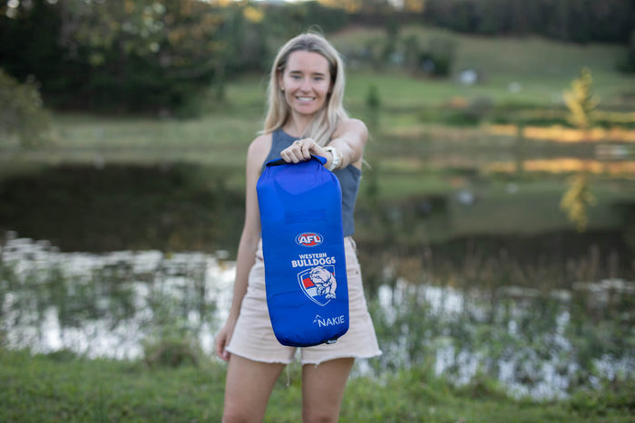 Blue Western Bulldogs AFL dry bag with drawstring closure held by woman outdoors
